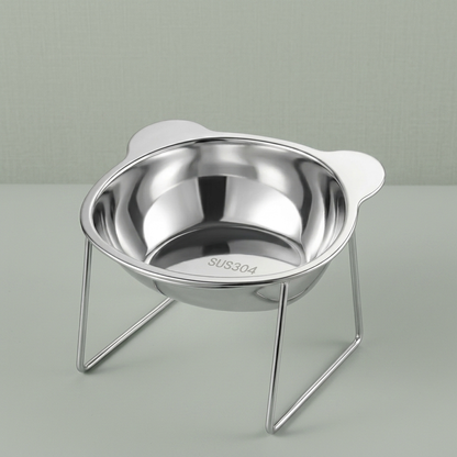 The tilted stainless steel cat bowl on its wire stand, on a plain background.