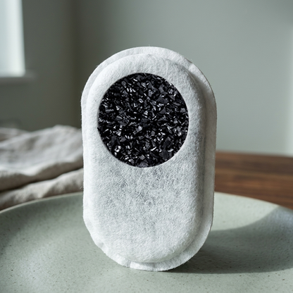 Cut-away view of a carbon filter pad showing the activated carbon inside its non-woven fabric shell.
