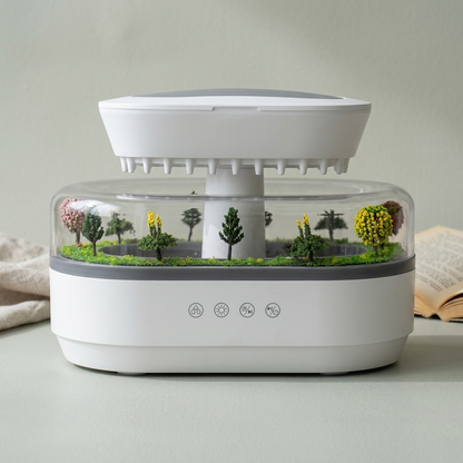 The raindrop humidifier on a plain background, its miniature landscape visible through the clear chamber.